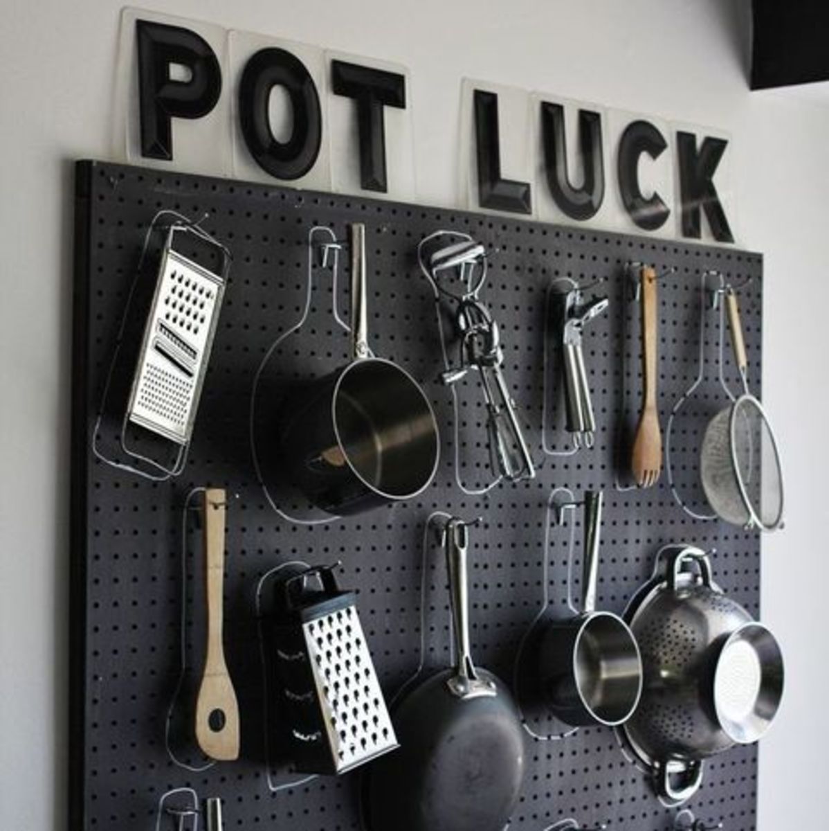 A black pegboard transforms a bare, blank wall into a stylish room. Hang your pots and pans on hooks and draw a chalk circle around them so you don't forget where they belong.  