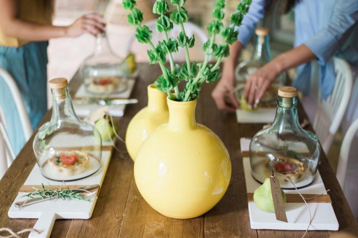 The great table with the greenery clippings in the yellow vases!