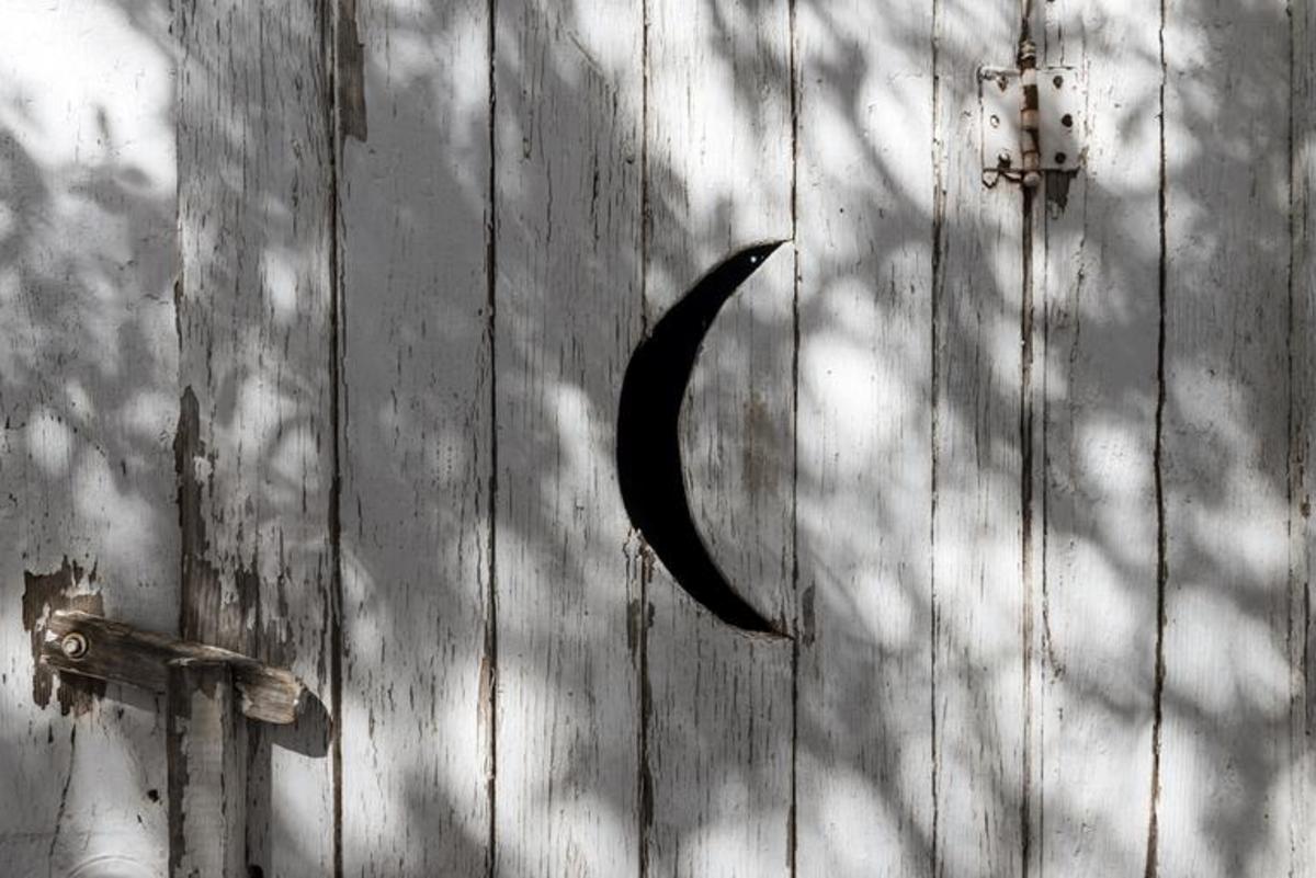 The outhouse doors have cut-outs on them. The crescent moon is for the women, and star cut-outs are for the men. 