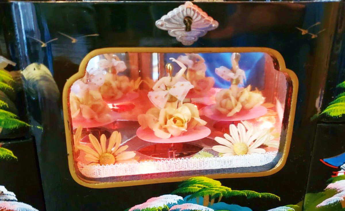 The three mirrors inside the lighted stage makes the blonde dancer appear to be four or more individual dancers on a miniature lighted stage. 