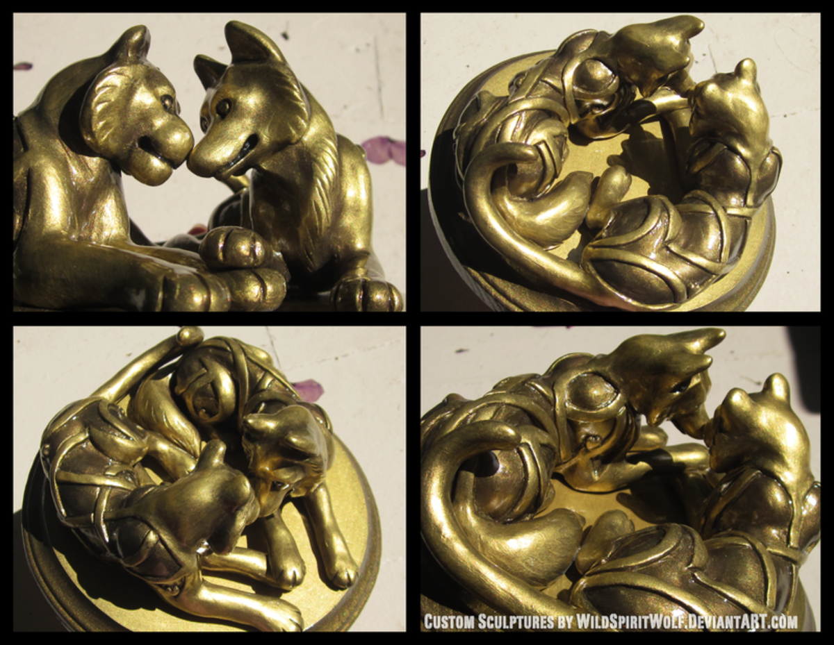 This cake topper depicts a feline and a canine laying affectionately side by side. The figures are bronzed to give the piece a more balanced appearance. 