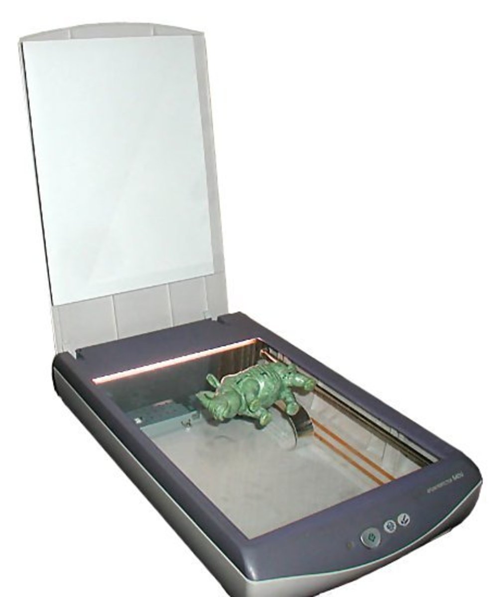 Desktop scanner, with the lid raised and an object  laid on the glass, ready for scanning