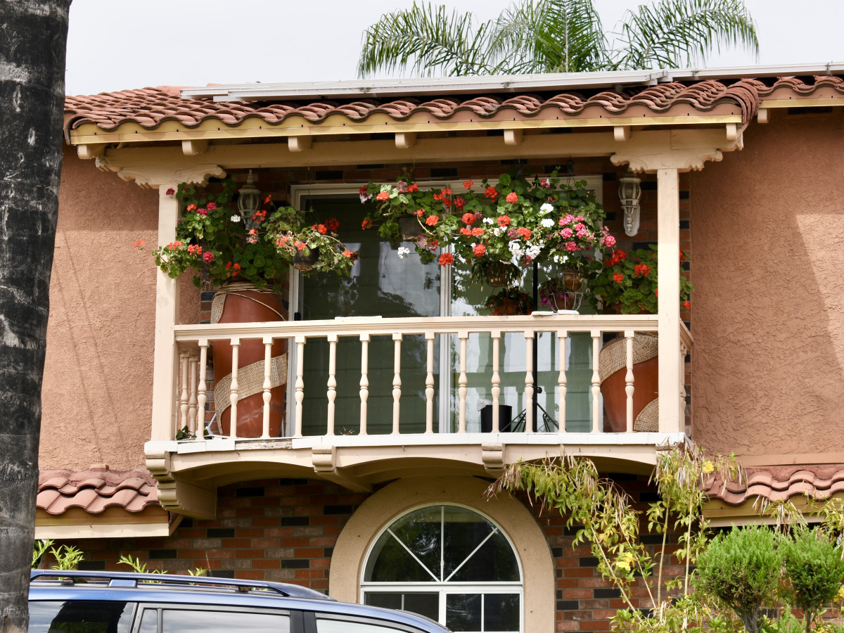 I've only seen two balconies in Pasadena, California, with flowers that can be seen from the street. These geraniums enhance the color of the house.