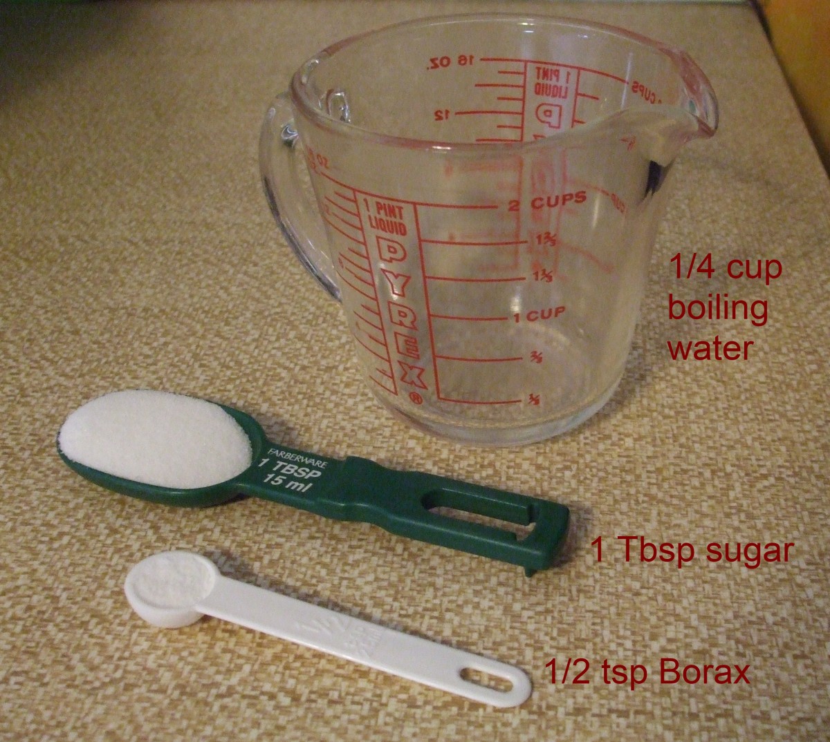 White table sugar, borax powder, and a Pyrex measuring cup for mixing with the boiling water.