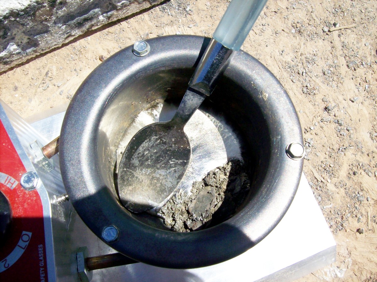 Skim the top of the molten lead and separate the contaminants—steel, copper, brass, and dirt—all of which are lighter than lead. The dirt, oxide, and small bits of metal float. The bullet jackets can be turned with a spoon and completely emptied.