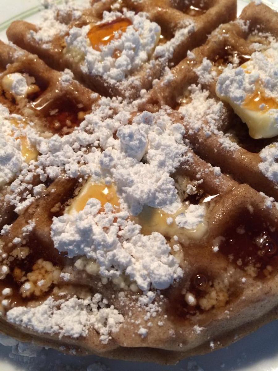 Gluten-free funnel cake waffles with real butter, powdered sugar, and maple syrup