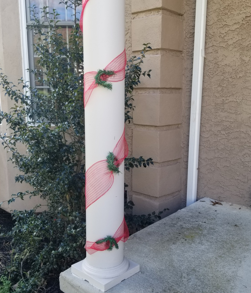 A little ribbon and greenery can make excellent Christmas decorations for exterior columns outside your home.