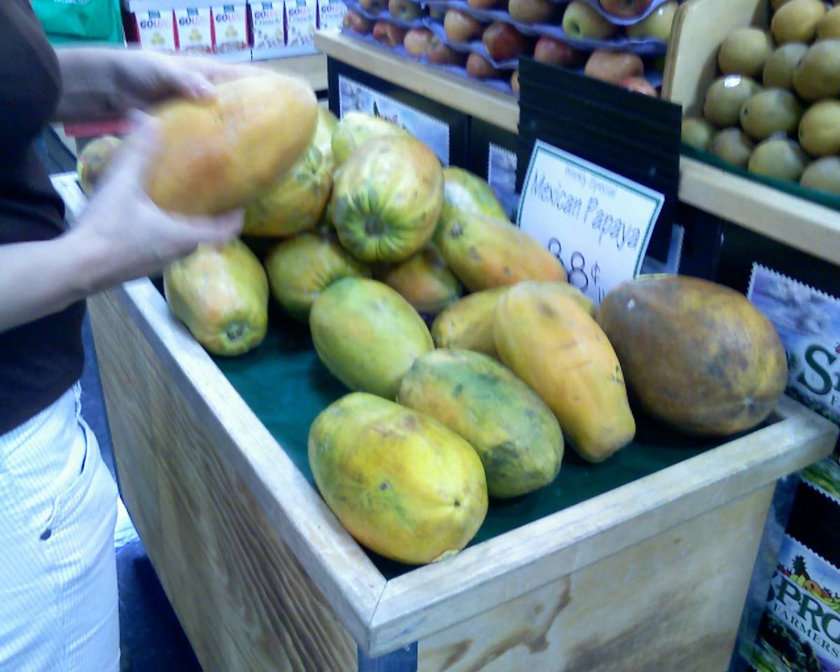 My wife selects a ripe papaya