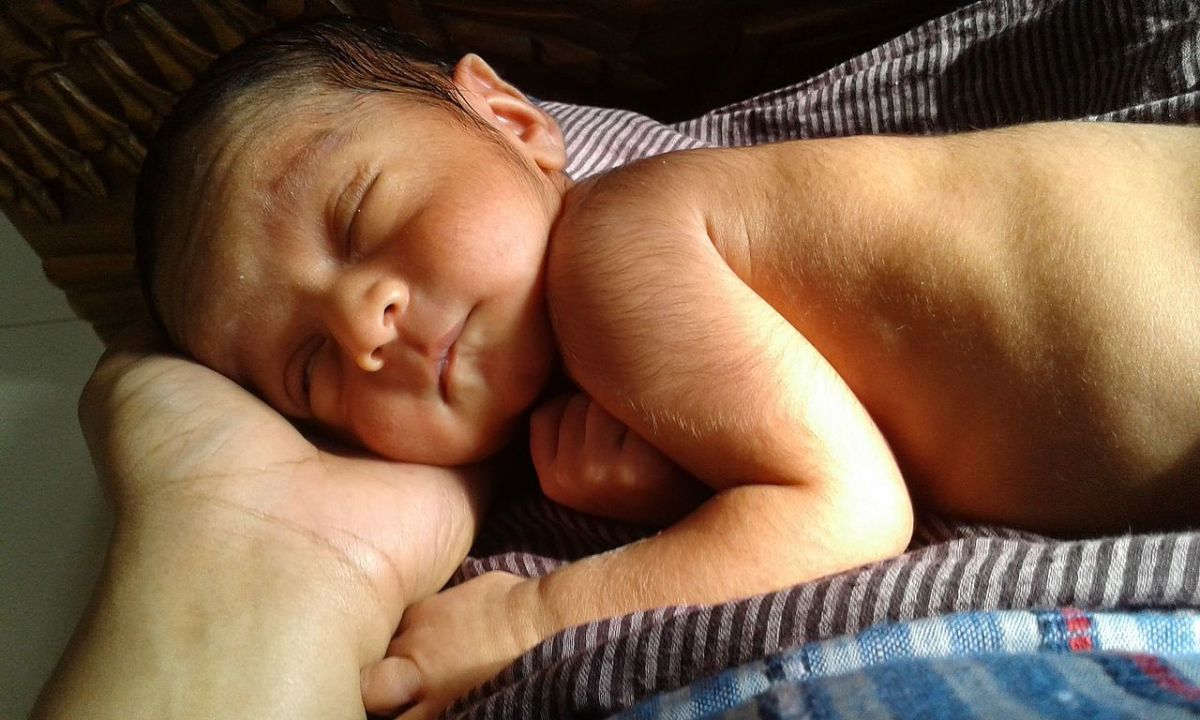 Child sleeping in mother hand.