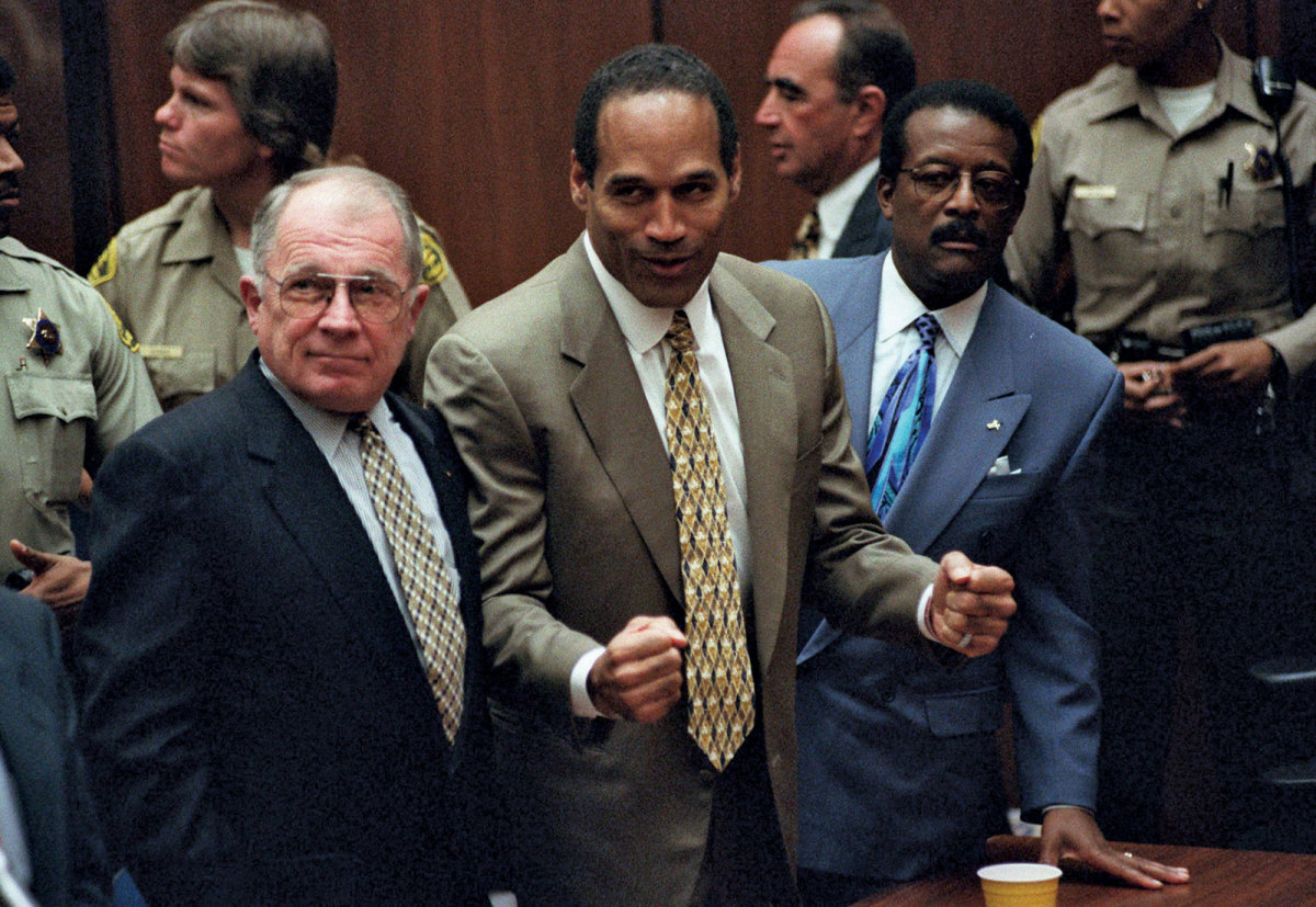 O.J. Simpson standing between defense lawyers F. Lee Bailey and Johnnie Cochran