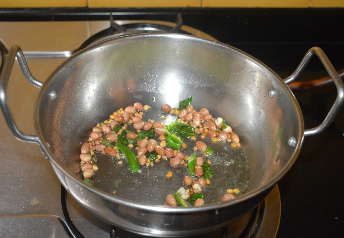 Saute the mixture over medium-low heat until the peanuts and split chickpea become golden brown and crispy. Add slit green chilies. Continue to saute for a few seconds.