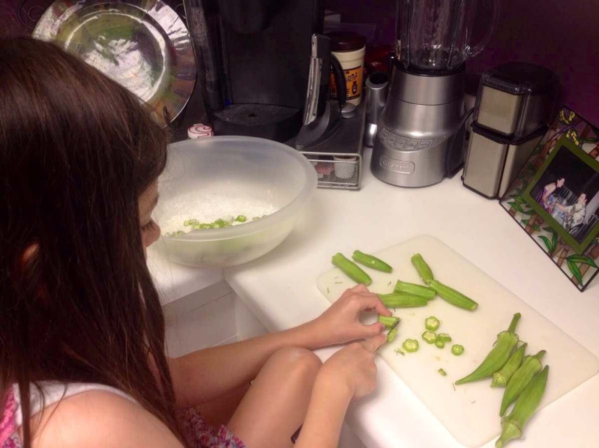 My daughter learning to slice the okra.