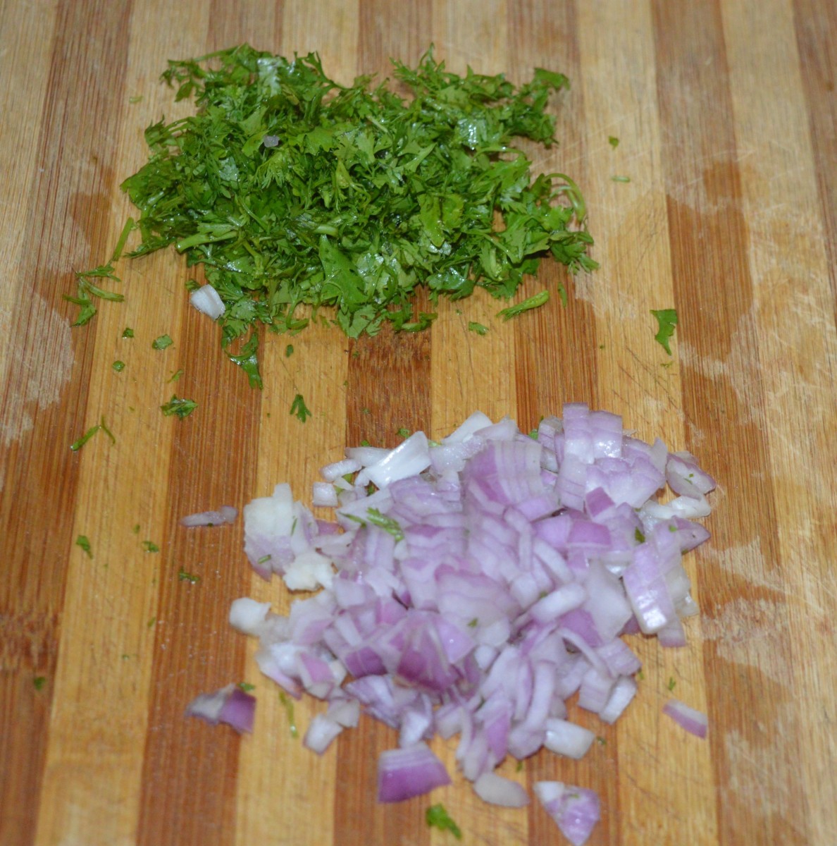 Adding water little by little, prepare a thin batter. Add chopped onions, and chopped coriander leaves. 