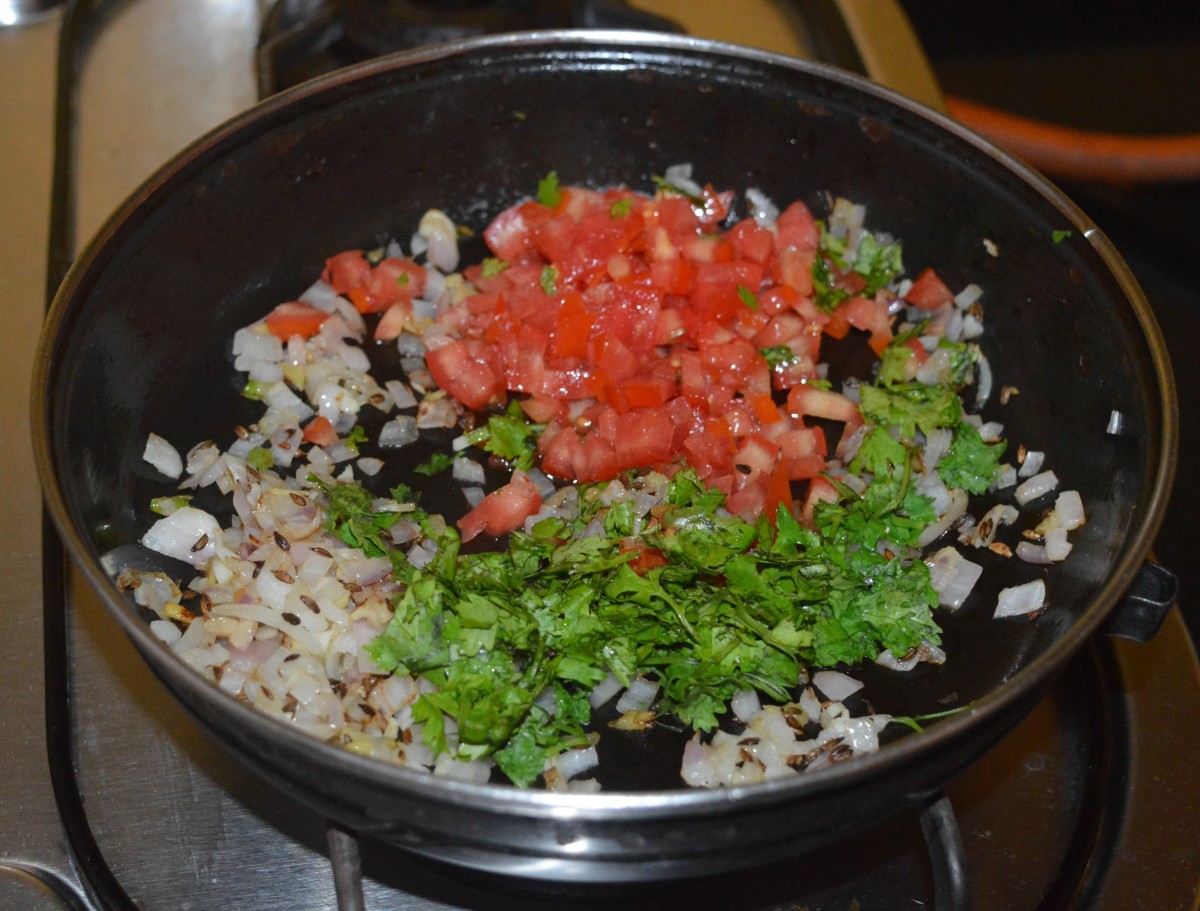 Add chopped tomatoes, coriander leaves, and some salt. Adding salt quickens the cooking process. 