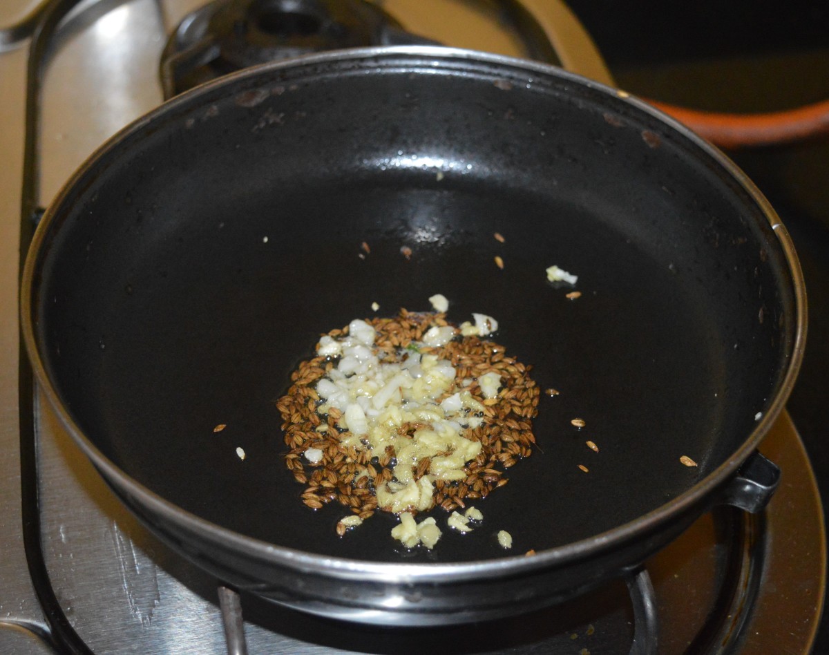 Step two: Heat oil in a deep-bottomed pan. Throw in cumin seeds and allow them to crackle. Add chopped ginger and garlic. Saute for 20 seconds.