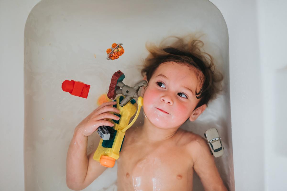 Most experts say you should start weening your child from bathing with you when they start school, although many kids need longer.