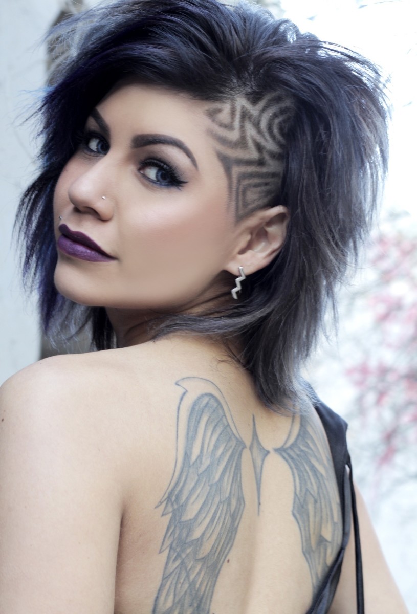 Woman with two tattooed wings, one per shoulder blade.