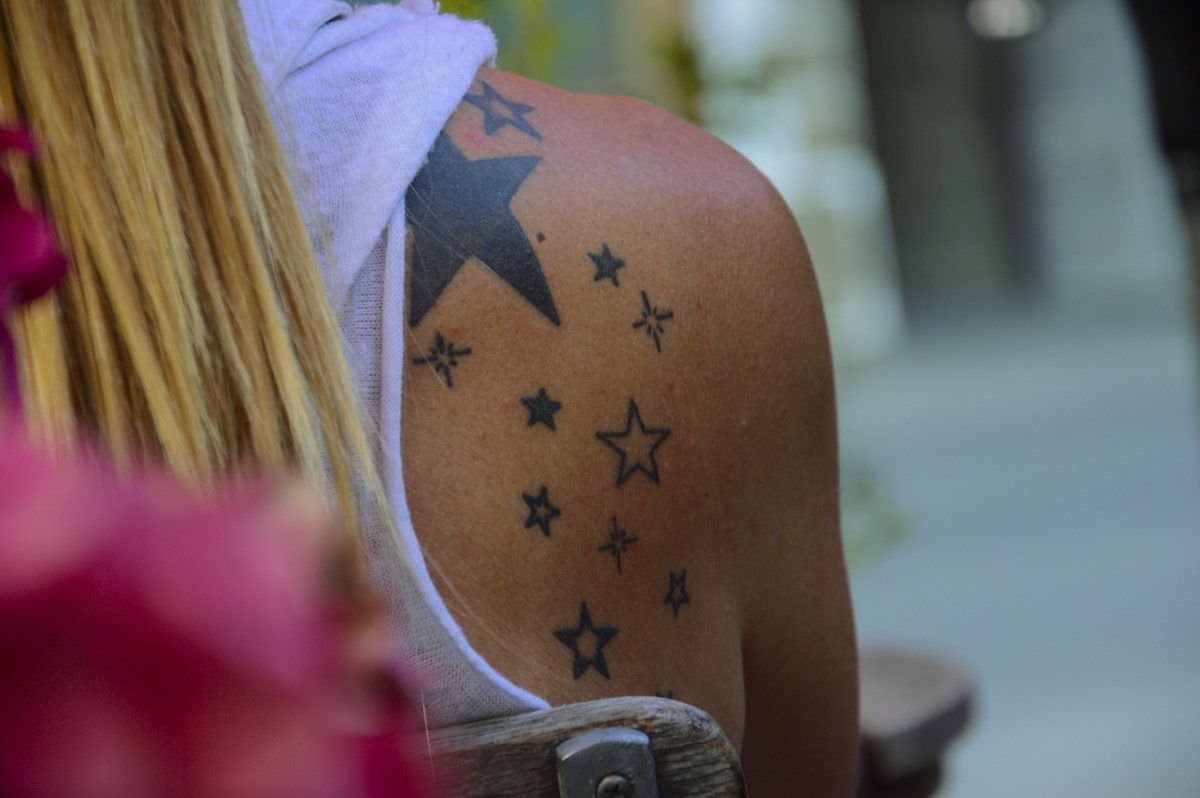 Woman with stars tattooed down her shoulder blade.