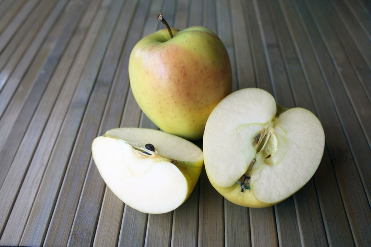 To remove the seeds, start by cutting the apple in half.