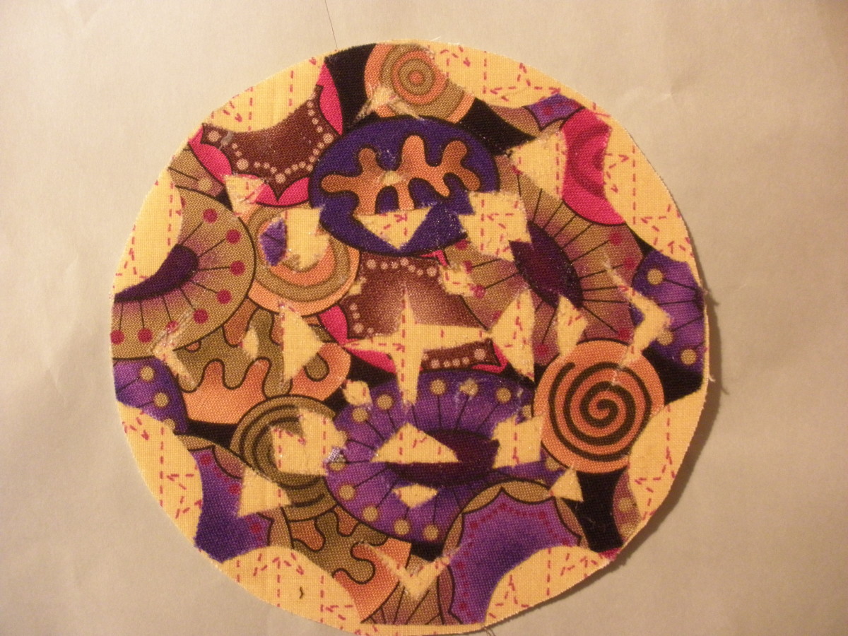 This coaster is made with Fast2Fuse.  The appliqué  was cut out free form from folded fabric, like a paper snowflake, and attached using Steam-a-Seam2.