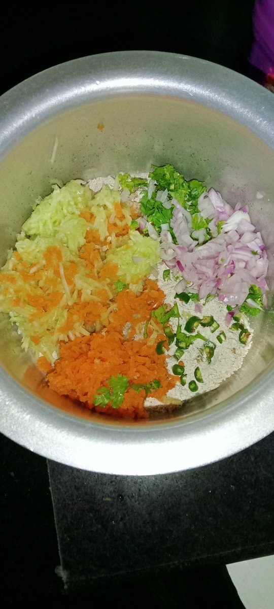 Add grated carrot, grated cucumber, chopped onion, chopped green chilli and chopped coriander leaves.