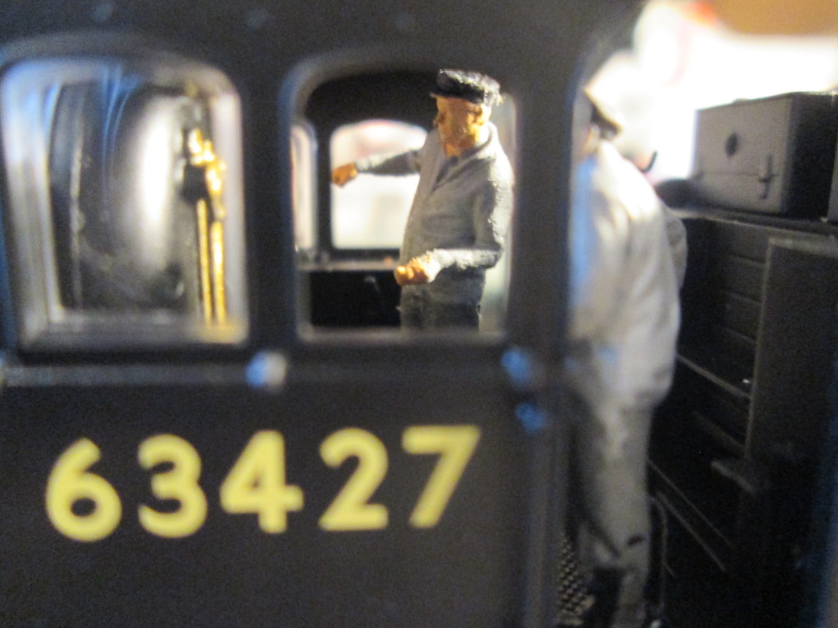 The human angle, crew on the footplate, driver checking levels ...