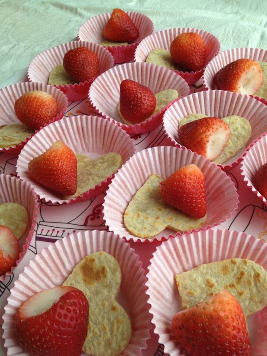 Healthy treat for valentine class party Heart shaped tortilla w melted cheese and a strawberry. Served in cute heart cupcake paper.