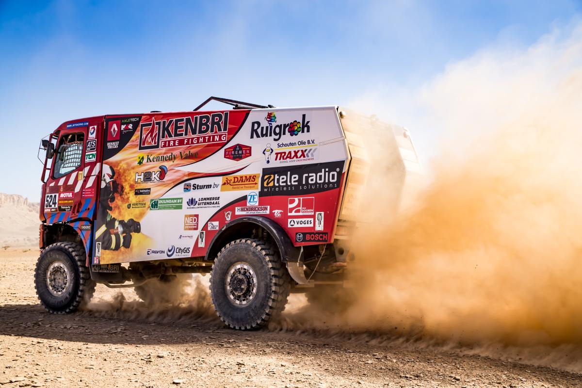 A racing truck making its way through the desert.