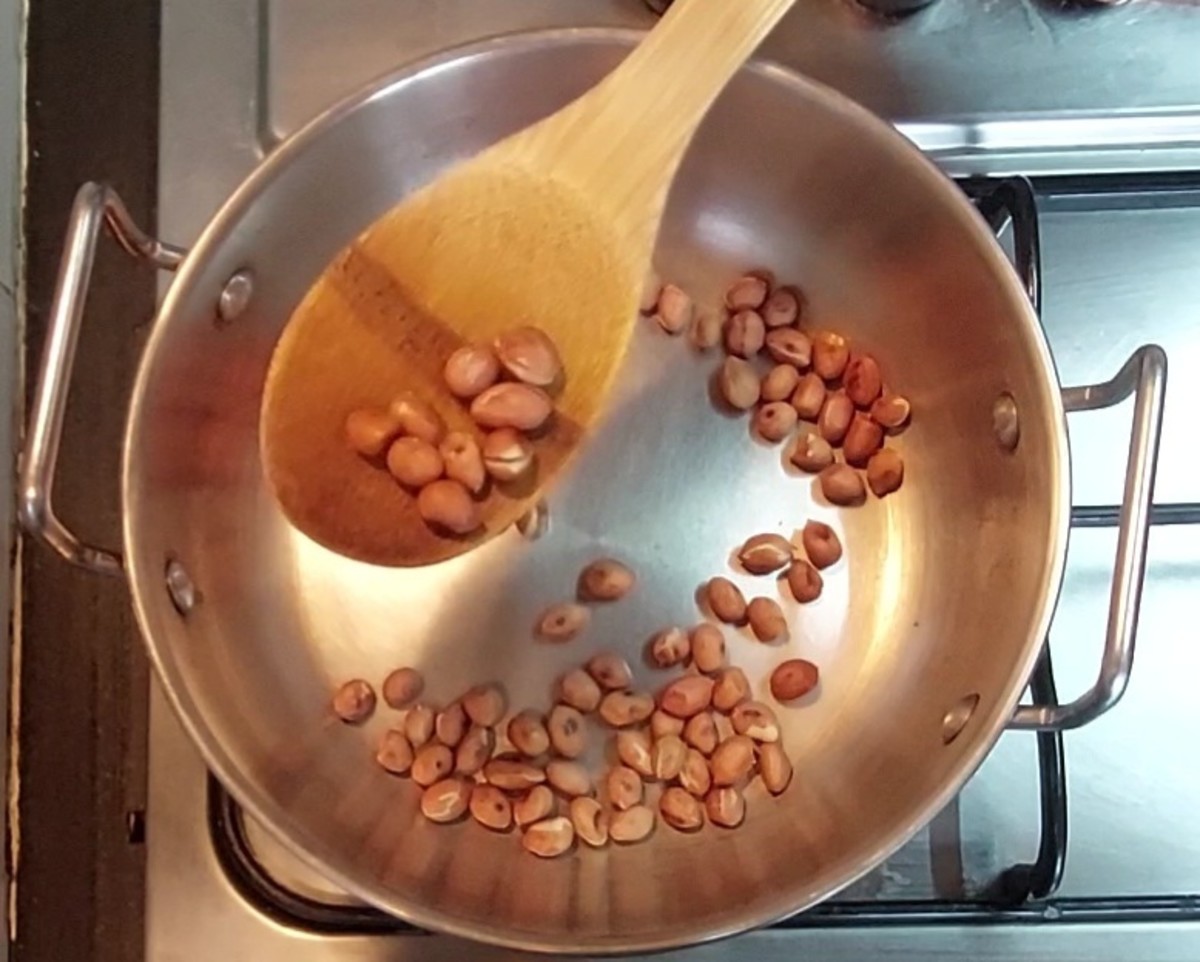 Add 1/4 cup peanuts to the same pan. Fry over low flame till the skins start to peel off. It may take around 2-3 minutes. Transfer to another plate.