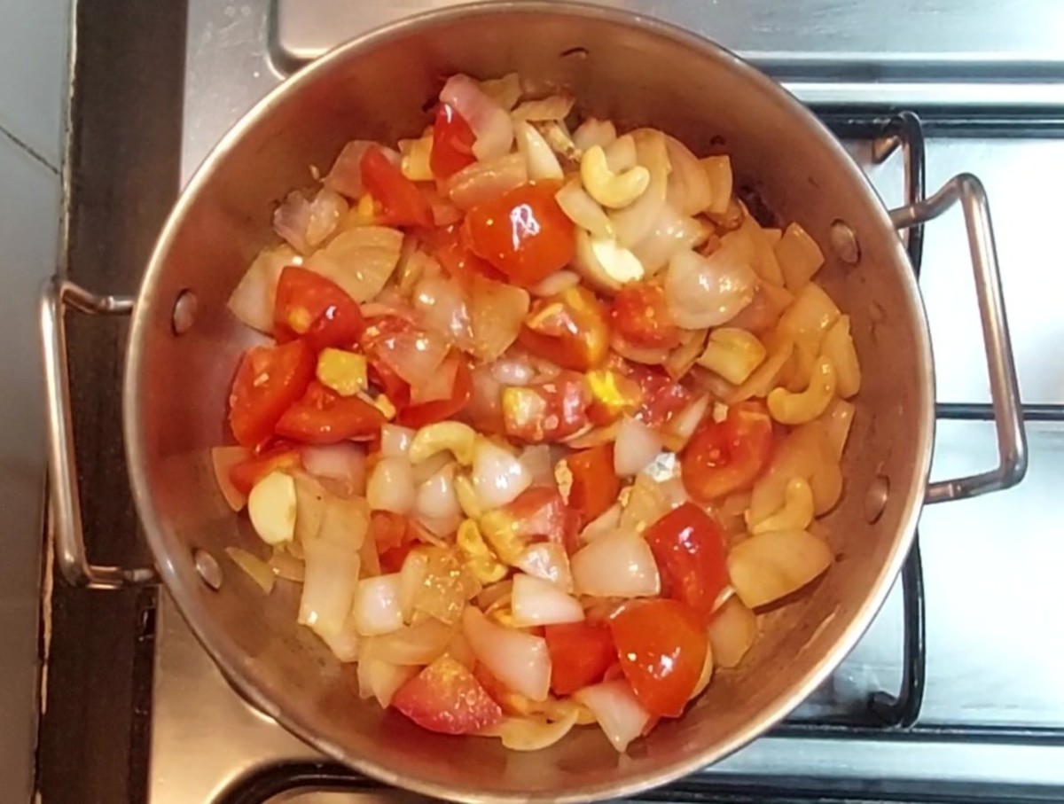 Add 2 chopped tomatoes and saute for a minute. Add 2-inch-long piece of chopped ginger, 5-6 peeled garlic cloves, 10 cashews and salt. Saute for 5 minutes or till onion and tomatoes are cooked. Switch off the flame.
