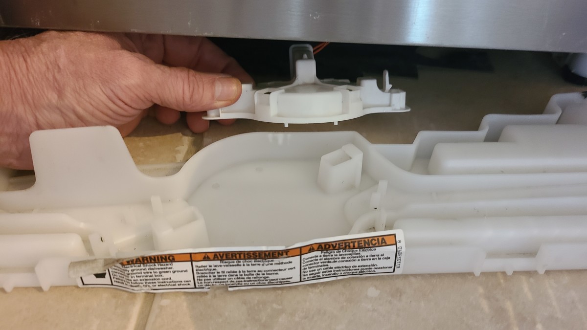 Press on the two small plastic tabs and lift the float valve out of the tray.