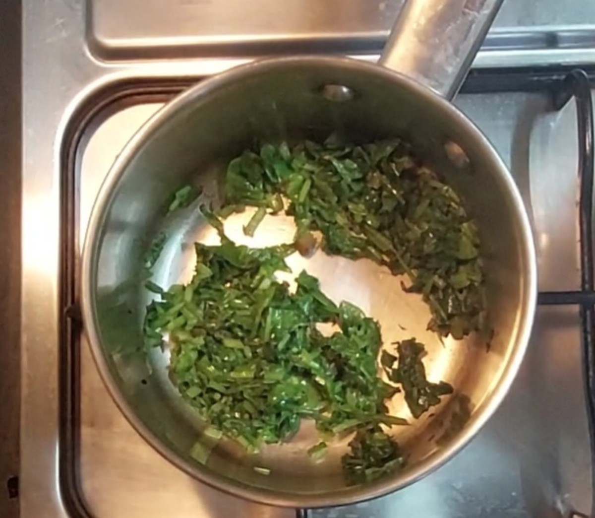 Fry till the spinach leaves shrink.