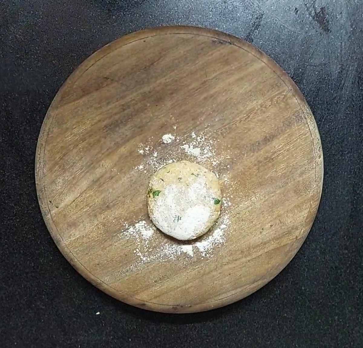 Take a ball of dough on a rolling board and dust with wheat flour.