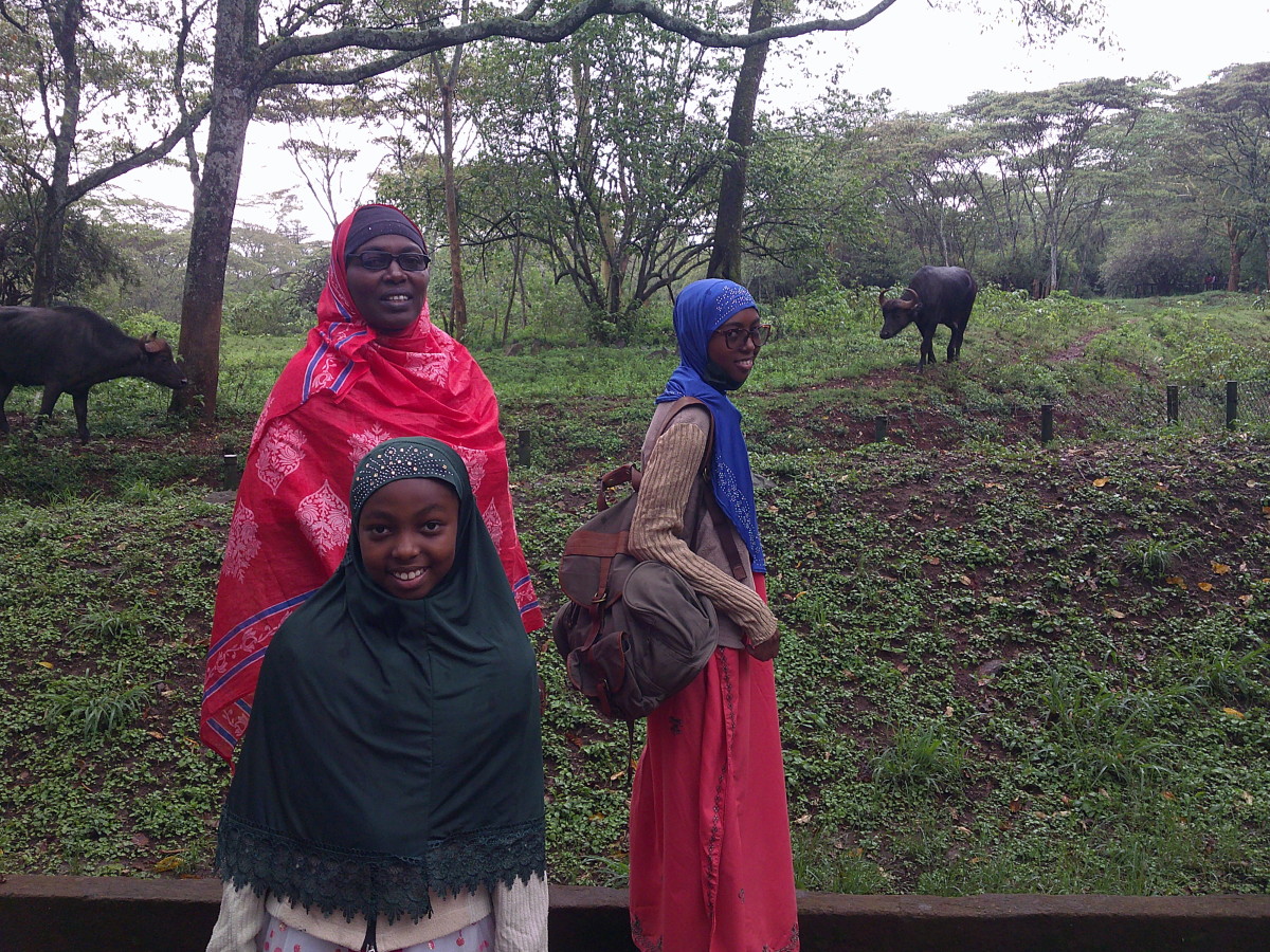 A mother and her daughters on the Nairobi Nature walk. Notice two buffaloes in the background