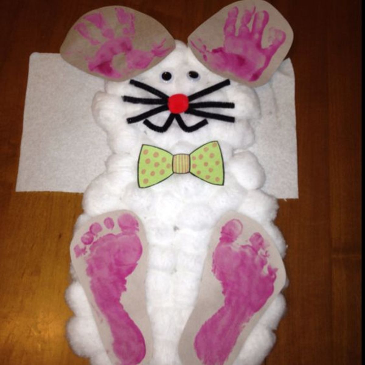 Easter bunny project for toddlers. Use cotton balls onto construction paper cut for bunny's body. Hands and feet with pink paint. Pipe cleaners for whiskers and mouth. Googly eyes and puff for nose. Tie for finishing touch.
