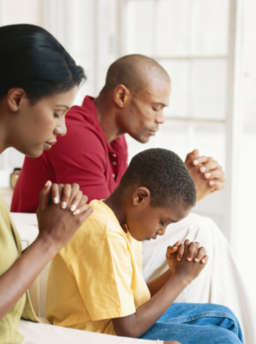 Parents praying with their only child. 