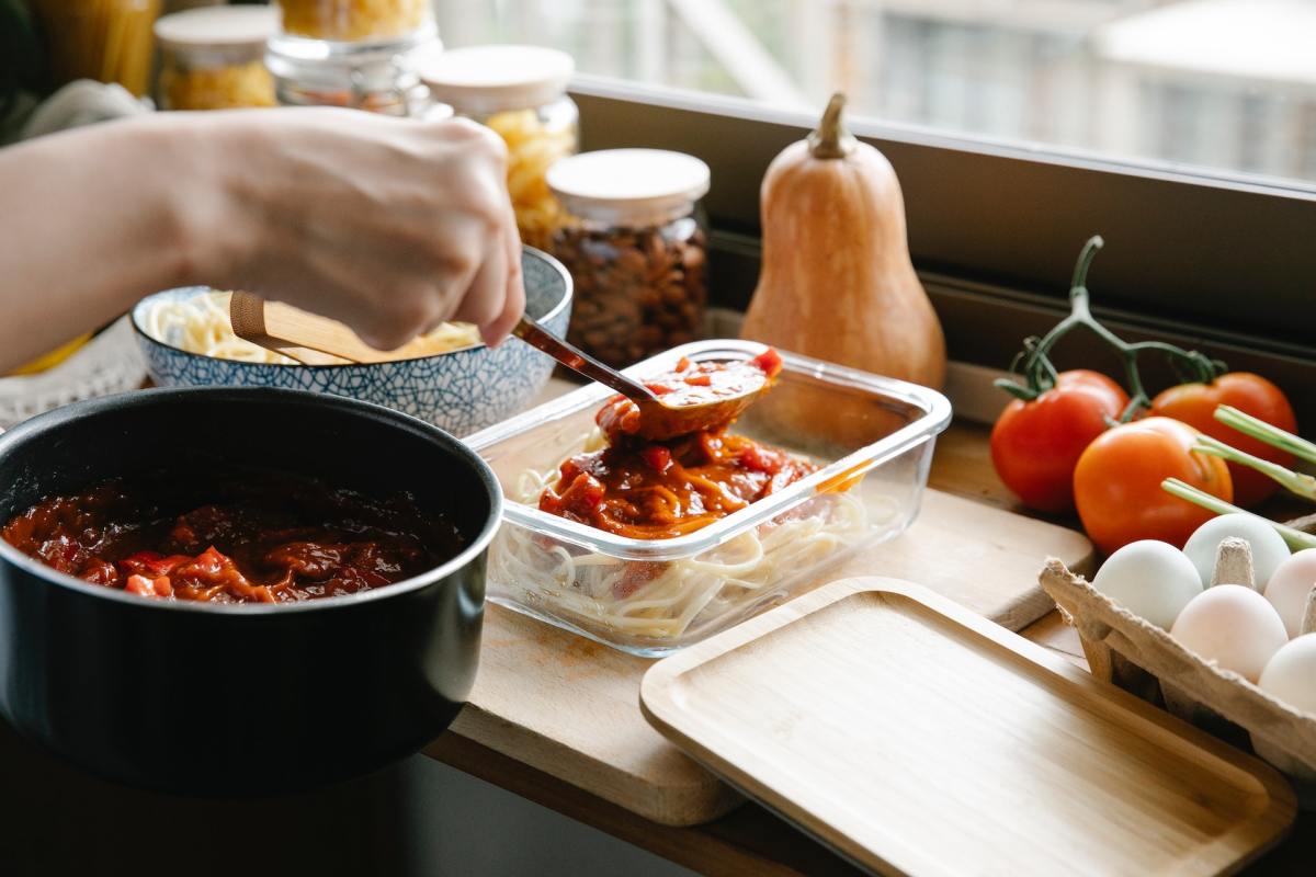 Photo by Sarah  Chai: https://www.pexels.com/photo/crop-chef-pouring-bolognese-on-spaghetti-7262351/