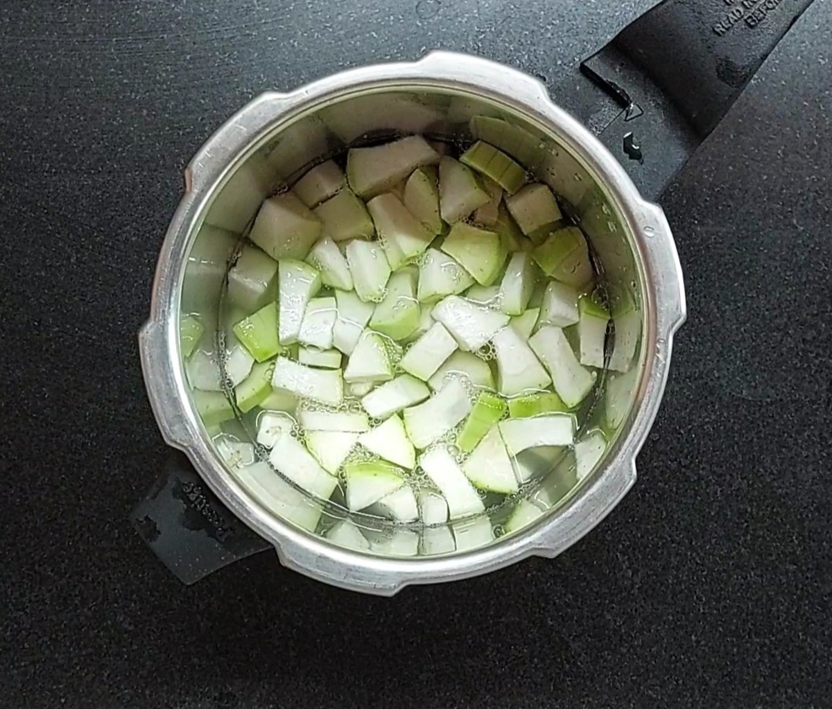 After soaking, discard water and transfer to the cooker. Add 1 cup peeled and chopped bottle gourd, 1 cup of water, salt, close the lid and cook for 3 whistles.