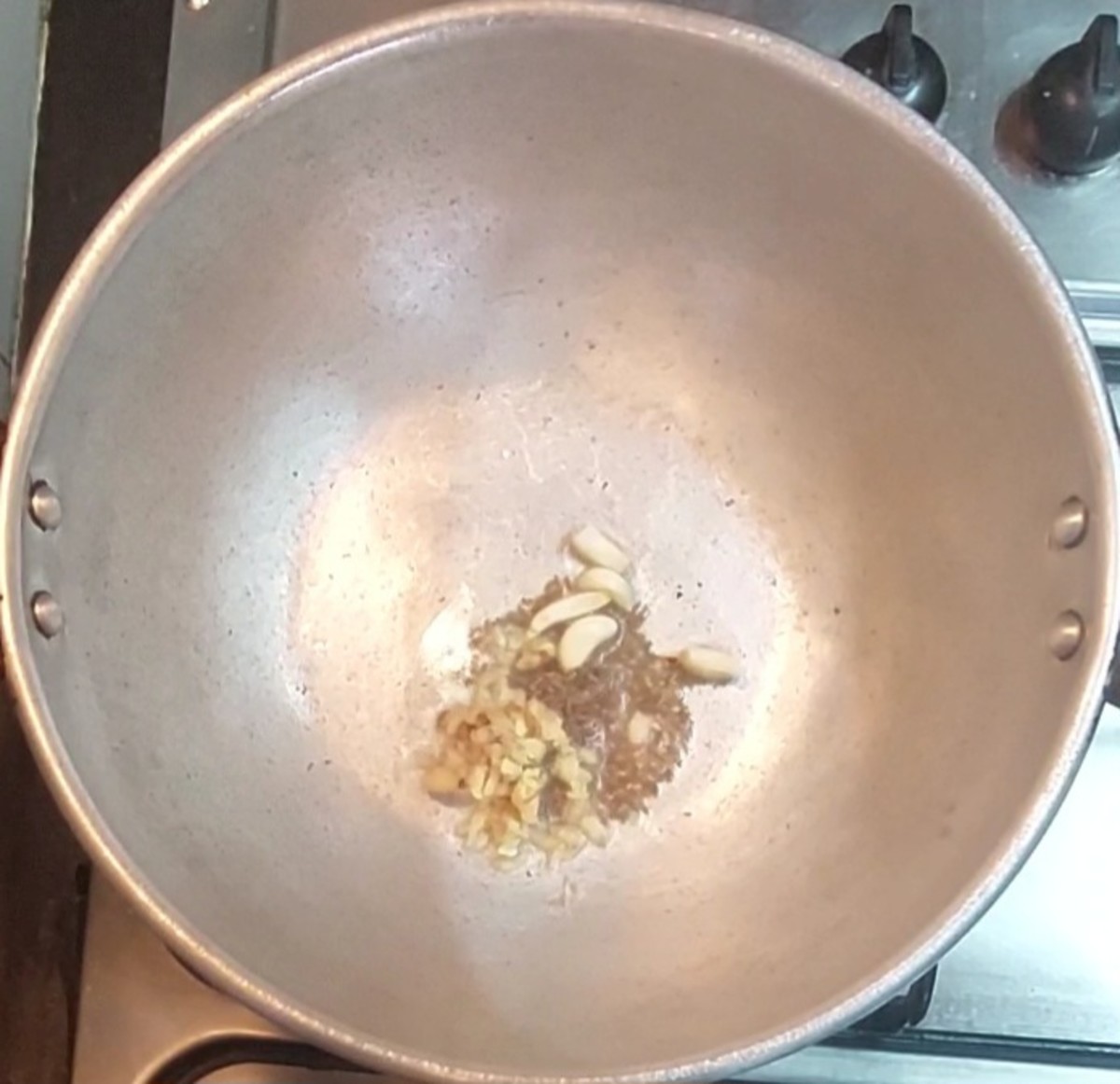 In a pan heat 2 teaspoons oil, splutter 1/2 teaspoon cumin seeds, add 1 teaspoon grated ginger, 4-5 garlic cloves, saute for some seconds.