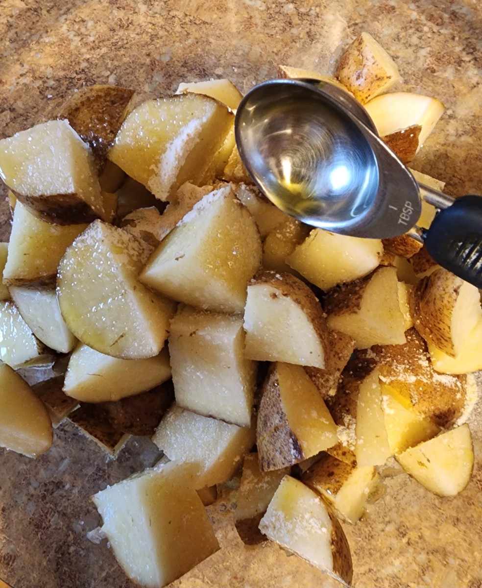 Place the potatoes in a mixing bowl. Add sea salt, garlic powder, and extra virgin olive oil. Toss with your hands to coat the potatoes well.