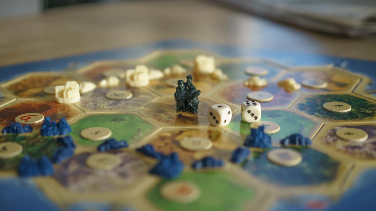 Some versions of Catan include the plastic components shown here, while others have standard wooden bits.