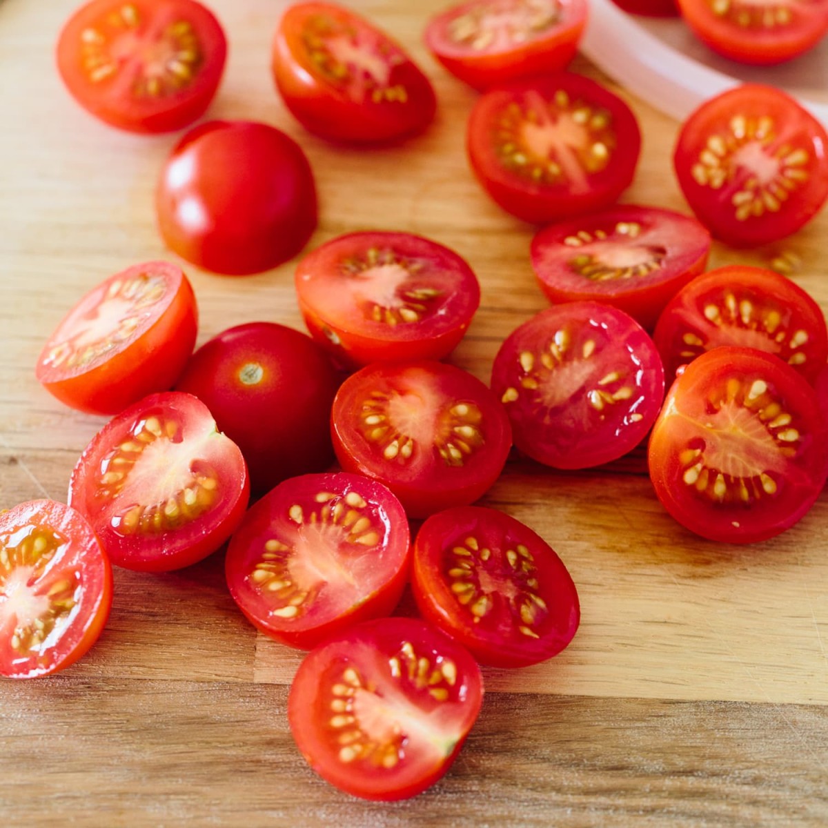 Cherry-tomatoes they are perfect for this dish, There a small tomato that has a shape like  Bing cherries and they are juicy and have very good flavor and if you sauté them, it brings out the total sweetness that takes then up another notch.