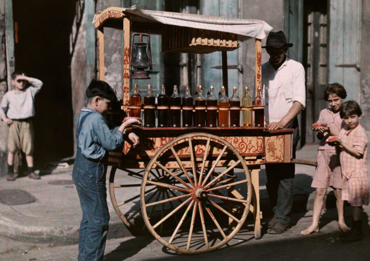 Autochrome image of children gathered around a French Quarter sno-ball vendor, published in the April 1930 issue of National Geographic.