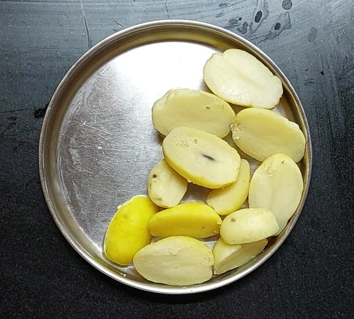 After the pressure of the cooker subsides, transfer the cooked potatoes to a plate and let them cool down. After cooling down, peel off the skins.