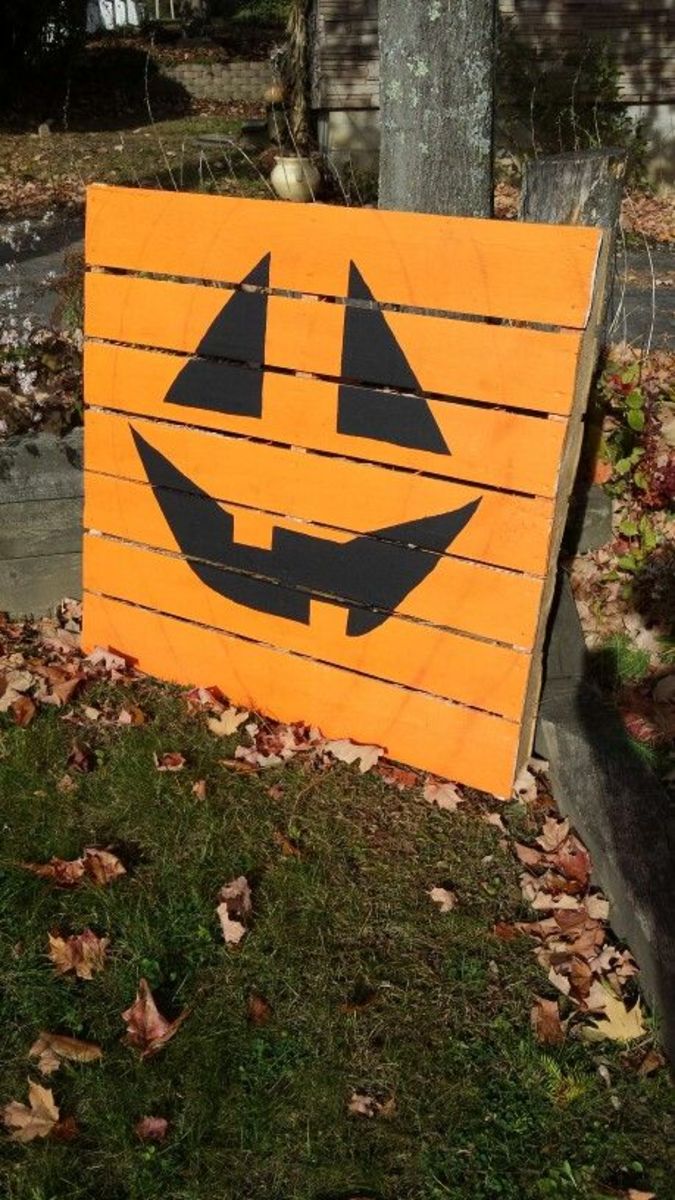a Pallet is painted orange to resemble a jack o lantern