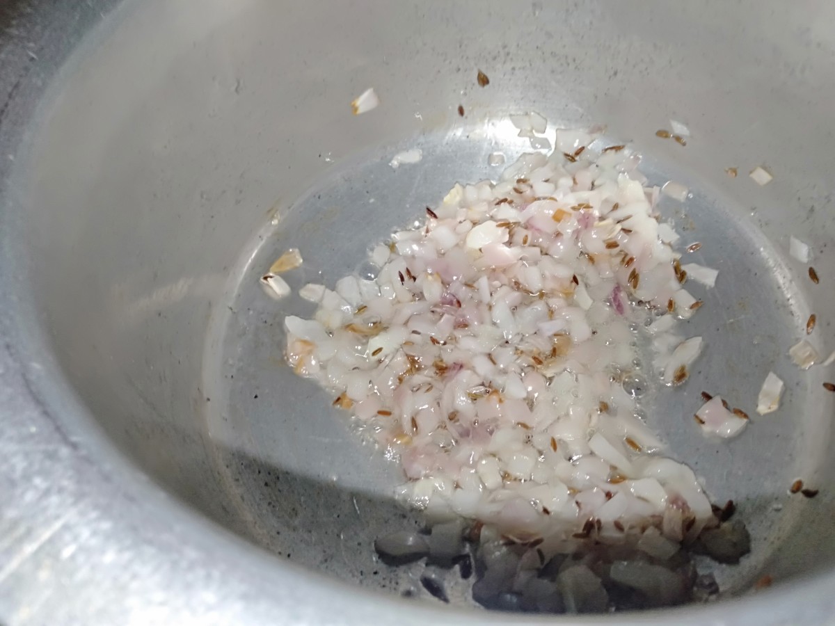 Once the cumin seeds crackle, add in the chopped onion and sauté well until translucent.