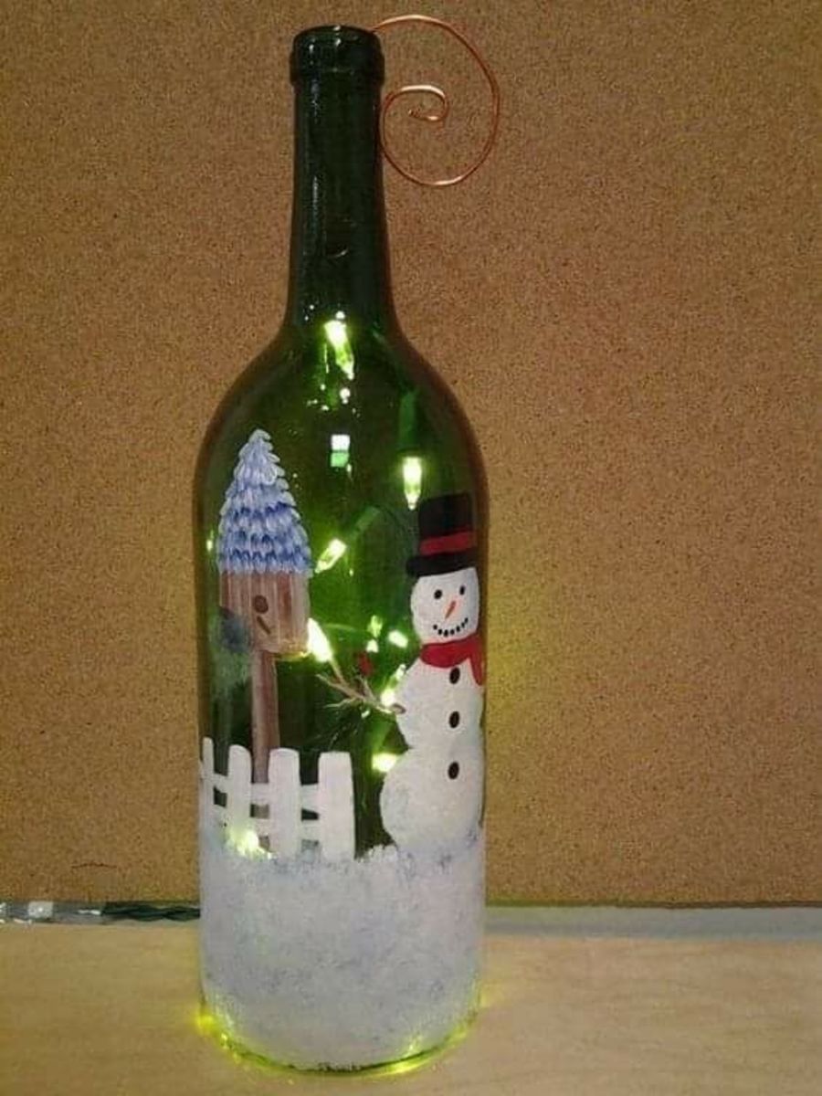 A delightful snowman scene painted onto a glass bottle