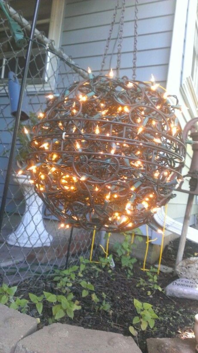 Wrought iron planters+Christmas lights = outdoor chandelier.