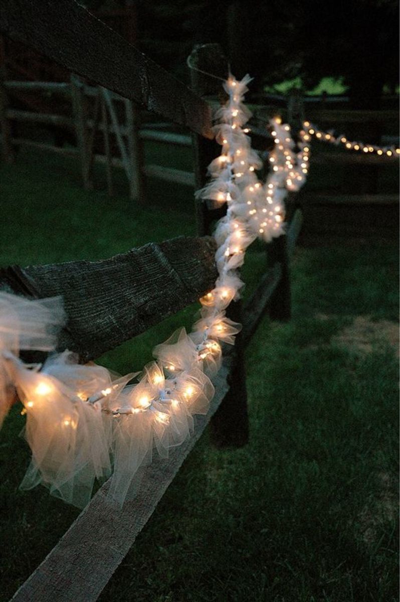 Tulle cut, tied inbetween each light and then hung around the fence