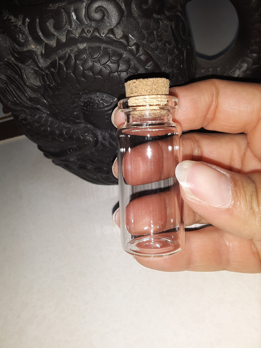 This miniature glass bottle has a wide lip. It is best to have a wide opening for the mask and rose charm. These craft bottles can be purchased at the dollar tree or craft store.
